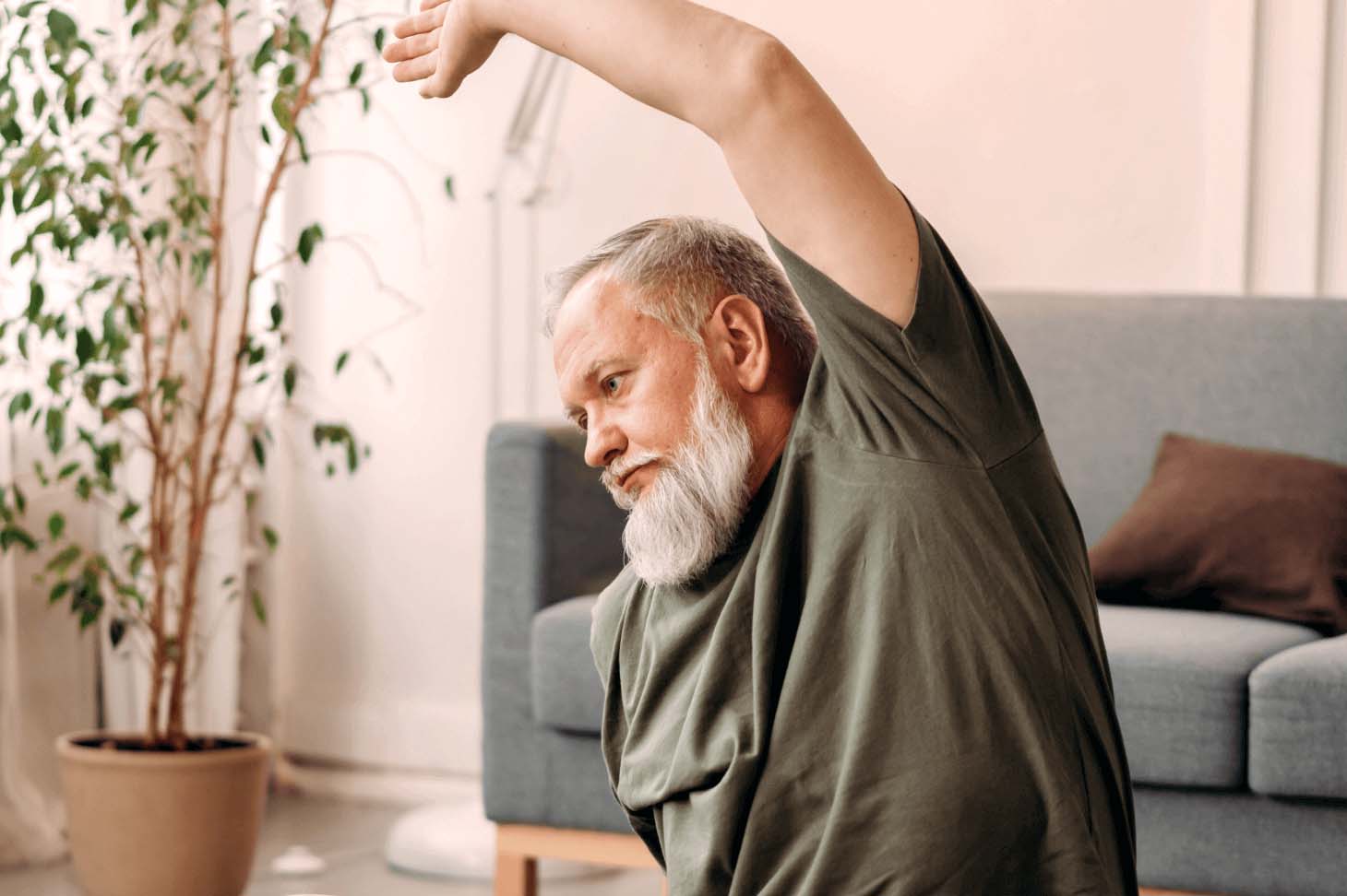 A middle-aged man stretching in a living room.